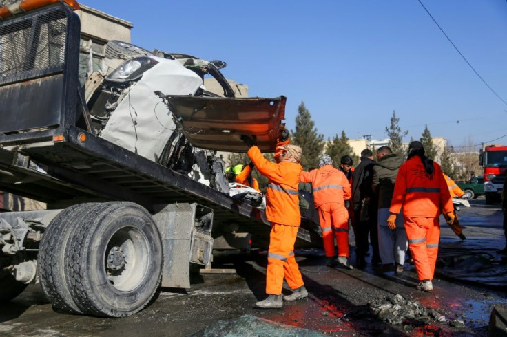 Municipal workers clean up debris from the site of a bomb attack in Kabul that killed five people, including two women prison doctors