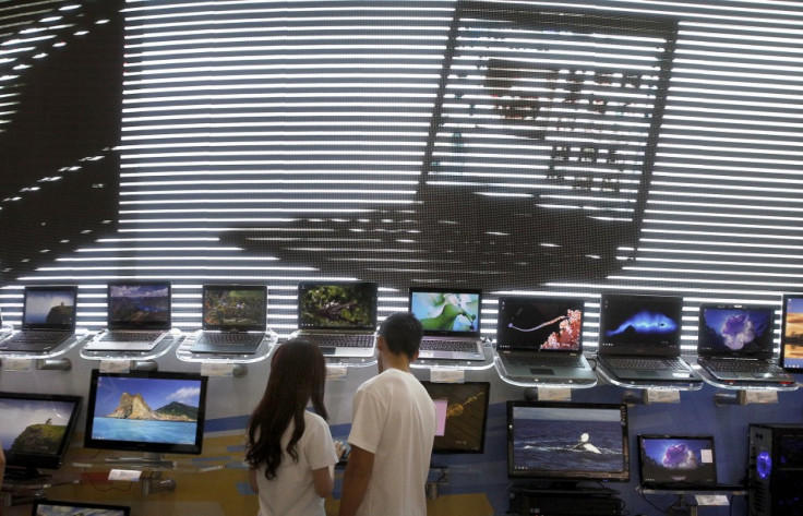 Visitors look at laptops displayed at the Microsoft booth during the Computex 2011 computer fair at the TWTC Nangang exhibition hall in Taipei