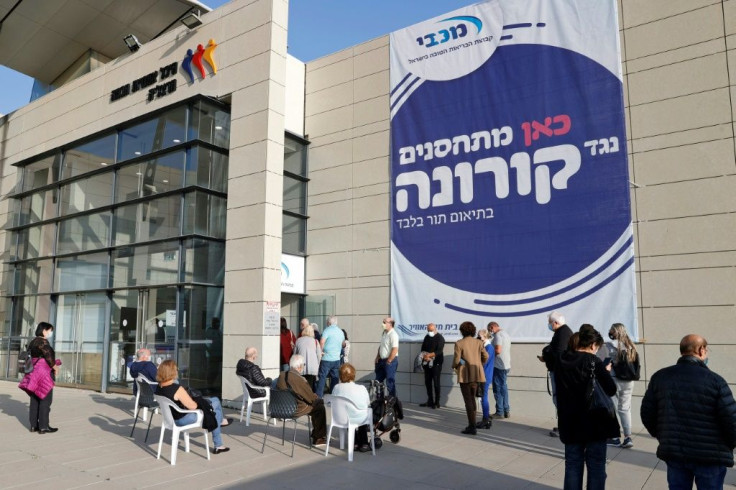 Seniors queue to get vaccinated against the coronavirus in the Israeli coastal city of Herzliya, north of Tel Aviv, on December 21