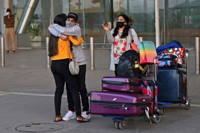 A passenger arriving from Britain is hugged by a relative at Sardar Vallabhbhai Patel International Airport in Ahmedabad before the ban on UK arrivals was imposed