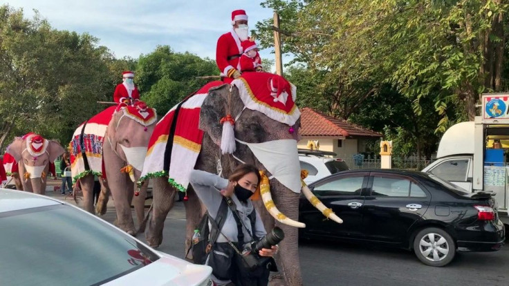 Dressed in red Santa Claus costumes, elephants and their handlers march to a school in the central province of Ayutthaya to hand out Christmas presents in the form of face masks to schoolchildren in light of the latest Covid-19 outbreak in Thailand. The e