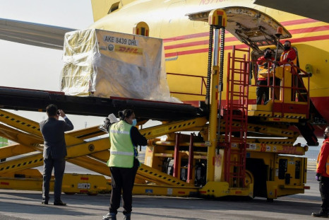 Workers unload Mexico's first batch of Pfizer-BioNTech vaccines from a plane at the capital's international airport