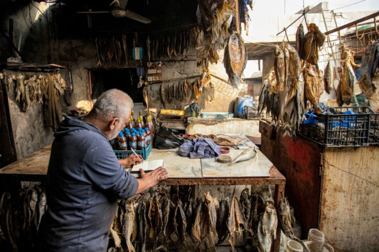 A fishmonger writes his Christmas message at his stall in Basra port