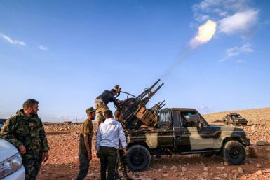 Libyan fighters loyal to eastern strongman Khalifa Haftar fire guns during a funeral of a comrade in November 1, 2020; Haftar has urged his troops 'drive out' Turkish forces