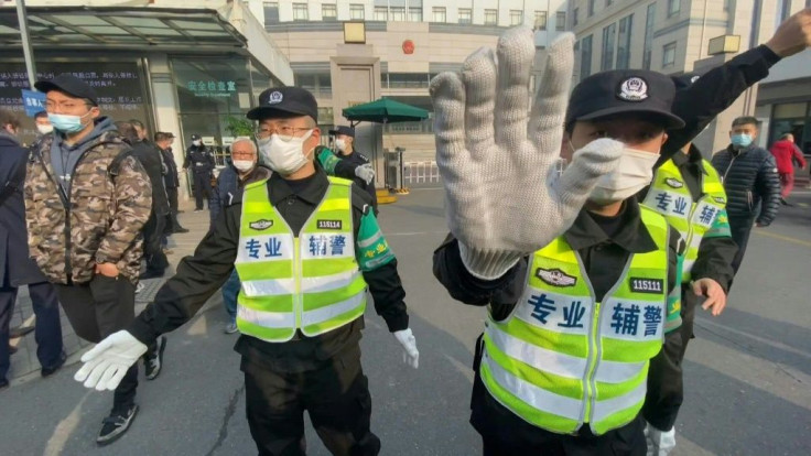 Police attempt to stop journalists from recording footage outside the Shanghai Pudong New District People's Court, where Chinese citizen journalist Zhang Zhan - who reported on Wuhan's Covid-19 outbreak and was placed under detention since May - was jaile