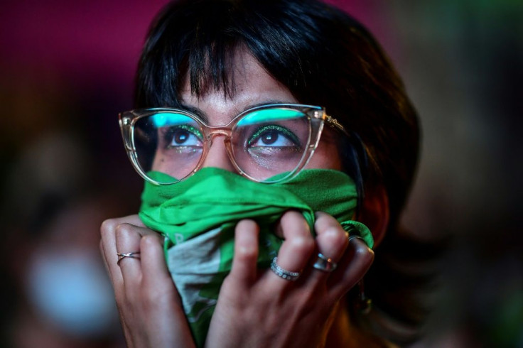 A pro-choice campaigner covers her face with the green scarf adopted by activists pushing for abortion to be legalized in Argentina