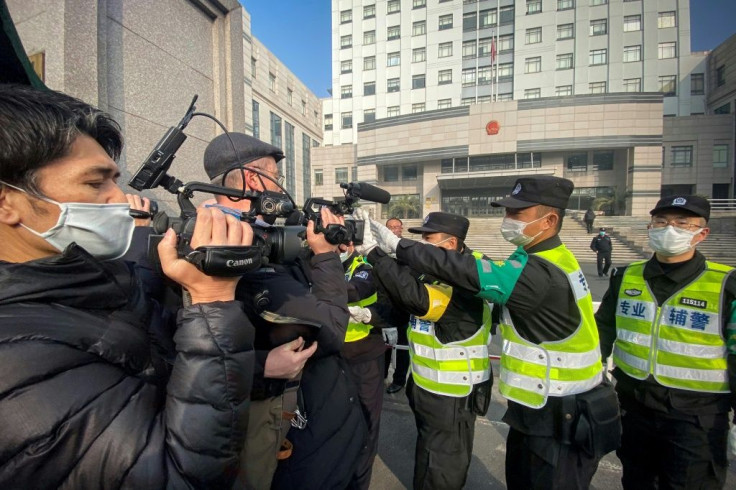 Police attempt to stop journalists from filming outside a Shanghai court where citizen journalist Zhang Zhan was tried for her early reports from Wuhan on Covid-19