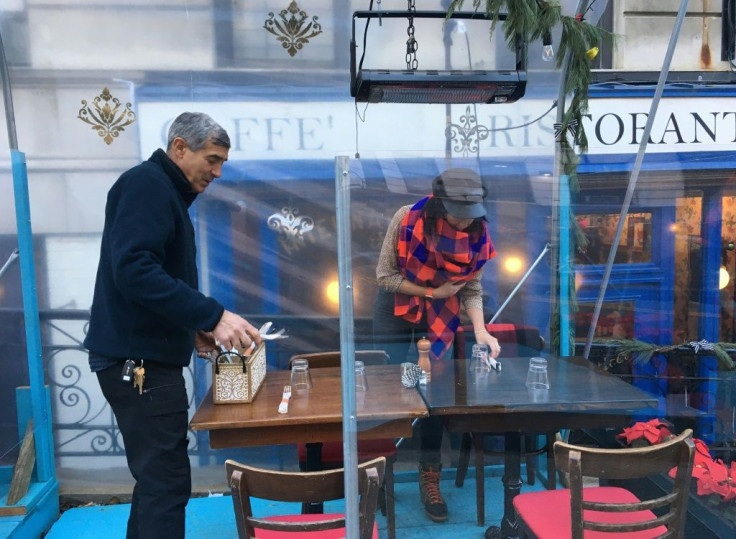 Pisticci restaurant and bar owners Michael and Vivian Forte set up a table outdoors in front of their establishment in New York