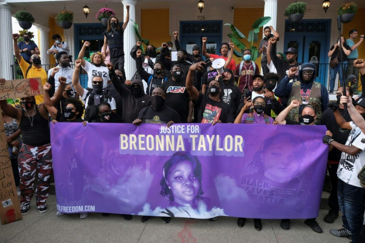 Demonstrators stand in front of a local restaurant on a third day of protests over the lack of criminal charges in the police killing of Breonna Taylor and the result of a grand jury inquiry, in Louisville, Kentucky, on September 25, 2020