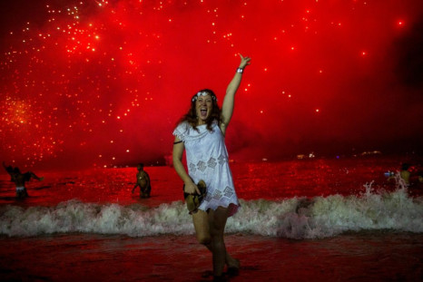 A woman celebrates at the traditional New Year's fireworks show at Copacabana Beach in Rio de Janeiro, Brazil in 2019. With not so many people following restrictions and authorities' orders and counter-orders to limit crowds during the end of the year hol