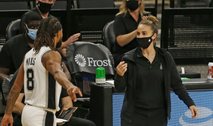 San Antonio Spurs assistant coach Becky Hammon talks with Spurs player Patty Mills at AT&T Center arena in Texas