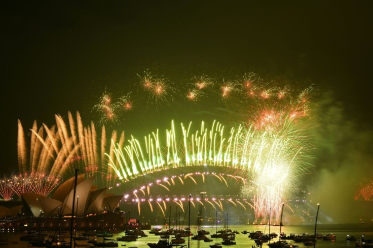 New Year's Eve fireworks erupt over Sydney's iconic Harbour Bridge and Opera House (L) during the fireworks show on January 1, 2021.