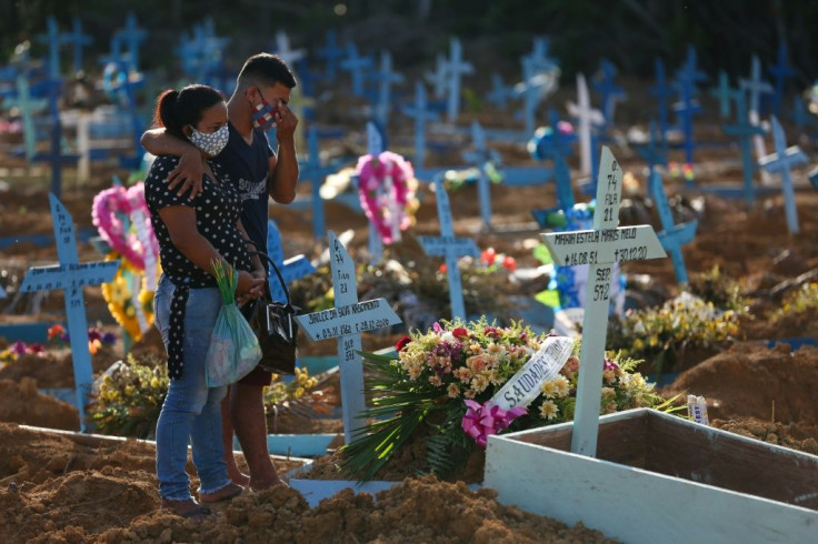 Relatives mourn during the funeral of Covid-19 victim Maria Estela Maris Melo, at the Nossa Senhora Aparecida cemetery in Manaus, Amazonas state, Brazil, on December 30, 2020, as the region sees a new surge in cases