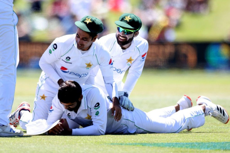 Pakistan's Haris Sohail dives to dismiss New Zealand's batsman Tom Latham as teamates Mohammad Rizwan (right) and Abid Ali celebrate