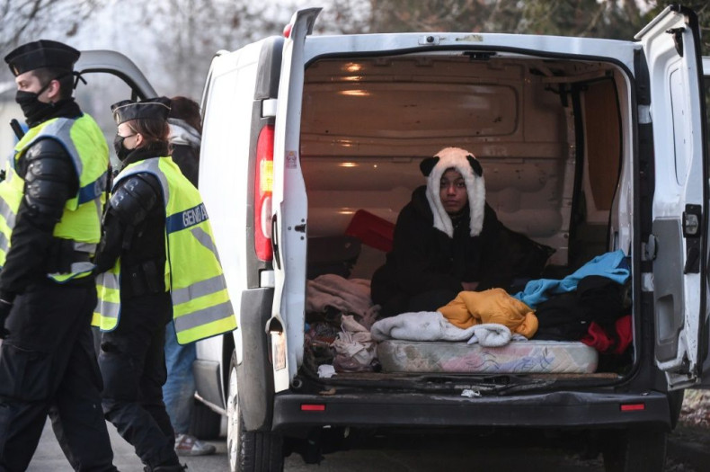 A raver wearing a panda hat sits in a van after being questioned by French police following the breakup of the event
