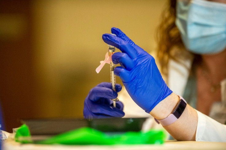 Pharmacist Colleen Teevan reconstitutes the Pfizer/BioNTech before having it administered to people at the Hartford Convention Center in Hartford, Connecticut