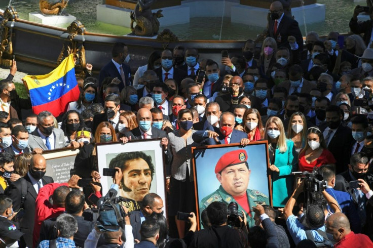 Venezuelan lawmakers carry portraits of revolutionary hero Simon Bolivar (L) and late socialist president Hugo Chavez (R) as they head to the National Assembly to be sworn in