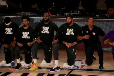 LeBron James and Anthony Davis kneel with Los Angeles Lakers teammates wearing Black Lives Matter shirts at an NBA game in July 2020