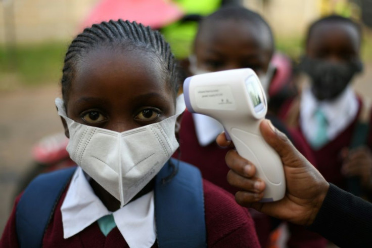 Kenyan students from Our Lady of Mercy Primary School Nairobi South have their temperature measured as they resume in-class learning after a nine-month disruption caused by the pandemic