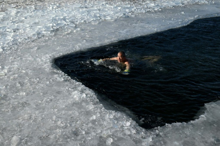 An ice swimmer braves a frozen lake on a cold winter day in Beijing