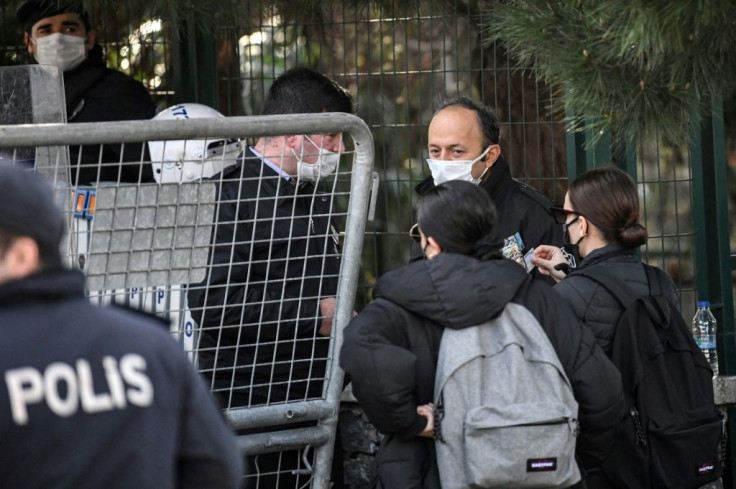Students show their IDs to enter the campus as Turkish anti-riot police officers guard the main gate of the Bogazici university on January in Istanbul during a protest against the appointment of the new rector by the Turkish president.