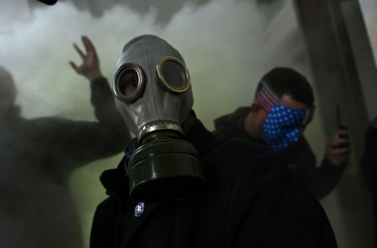 A supporter of US President Donald Trump wears a gas mask as he protests after storming the US Capitol