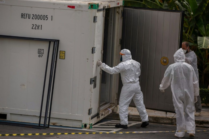 Health workers wear protective suits as they leave a body of a victim of the novel coronavirus in a refrigerated container at the Vinte Oito de Agosto Public Hospital, a unit treating COVID-19 patients in Manaus, Brazil January 4, 2021