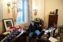 Richard Barnett, a supporter of US President Donald Trump, sits inside the office of US House Speaker Nancy Pelosi on January 6, 2021