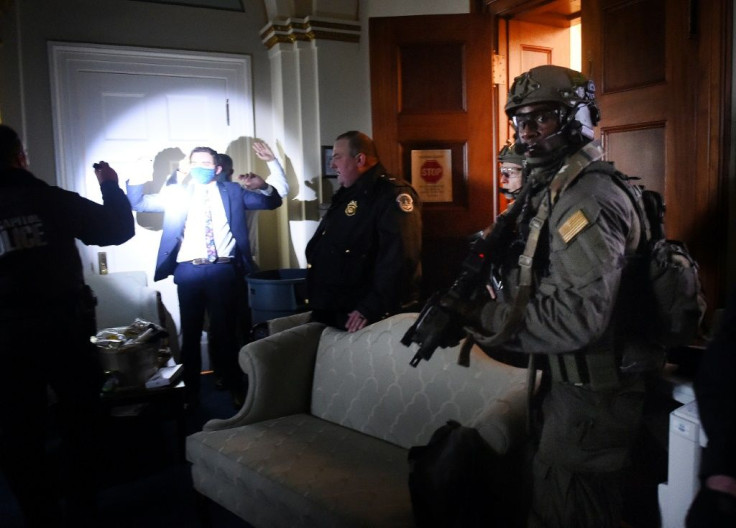 Congress staffers hold up their hands while Capitol Police SWAT teams secure the US legislature after it was stormed by right-wing protestors.