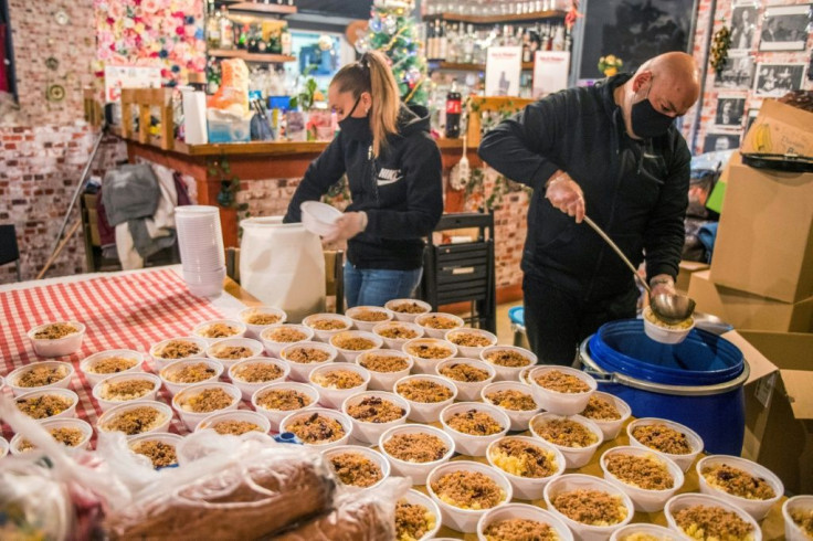 Norbert Bango (R) and his wife Vivien (L) have repurposed their restaurant's kitchen into a relief centre to feed Budapest's unemployed and needy