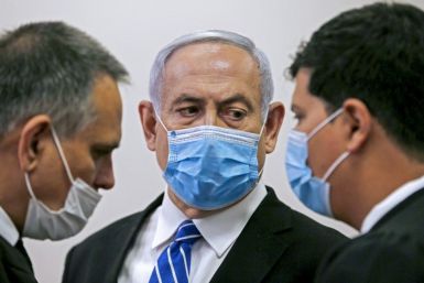 Israeli Prime Minister Benjamin Netanyahu confers with counsel during his sole court appearance so far in his trial for bribery, fraud and breach of trust -- the opening hearing on May 24 last year