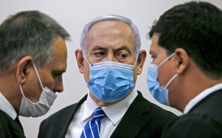 Israeli Prime Minister Benjamin Netanyahu confers with counsel during his sole court appearance so far in his trial for bribery, fraud and breach of trust -- the opening hearing on May 24 last year