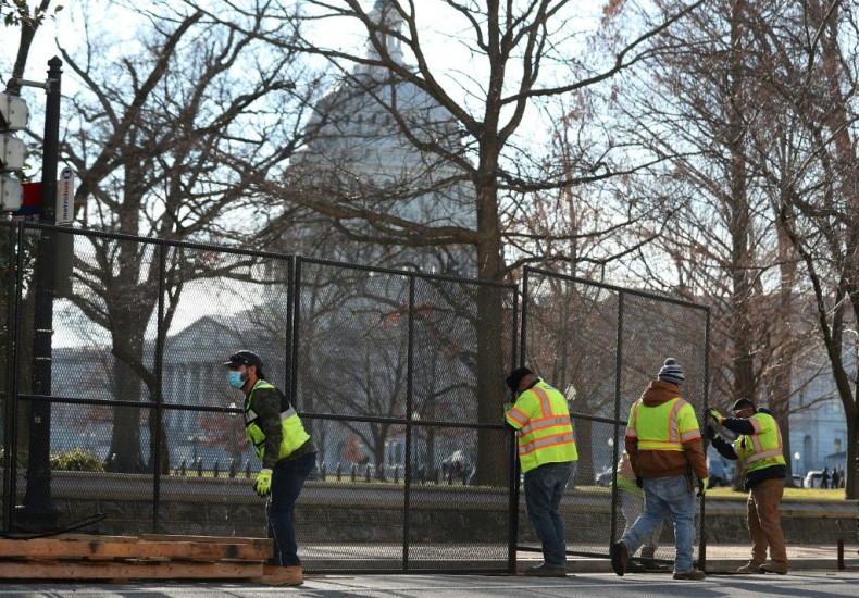 Workers erect a fence around the US Capitol a day after a pro-Trump mob broke into the building