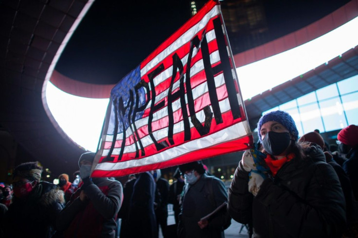 Demonstrators hold a banner calling for impeachment of US President Donald Trump during a protest outside the Barclays Center in Brooklyn, New York