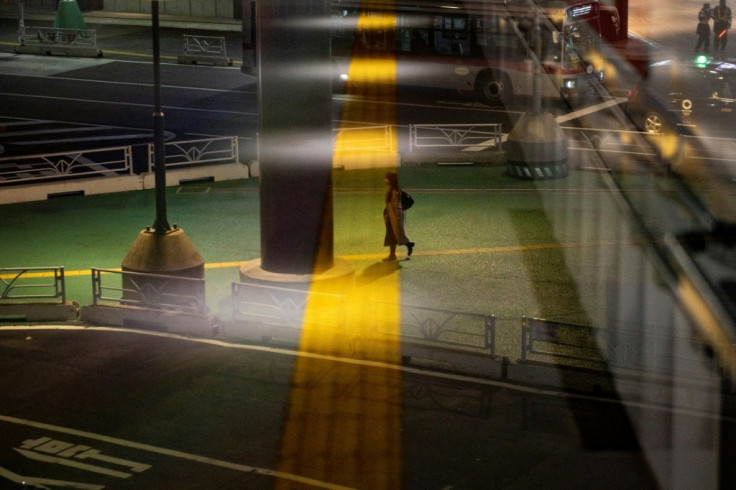 A woman walks at Shibuya district in Tokyo during the first day of a state of emergency over the Covid-19 coronavirus pandemic