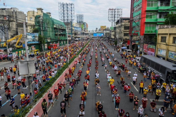 Catholic devotees attend mass on a road near Quiapo Church in Manila