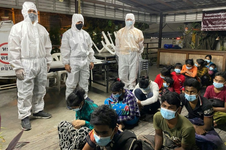 Immigration officers watch over the group of Rohingya who are said to have illegally entered Thailand after being smuggled overland from Myanmar's Rakhine state