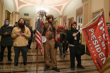 Supporters of US President Donald Trump, including member of the QAnon conspiracy group Jake Angeli, aka Yellowstone Wolf (C), enter the US Capitol