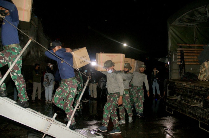 Marines load supplies and equipment on a ship for a search and rescue operation for the Sriwijaya Air flight SJY182 in Jakarta on January 9, 2021