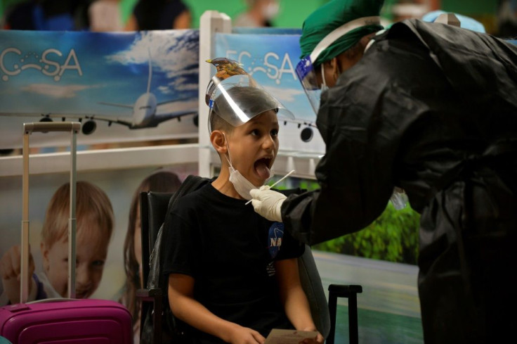 A health worker conducts a COVID-19 test on a child at Jose Marti International Airport on November 15, 2020, as commercial flights resumed in Havana after almost eight months' suspension amid the coronavirus pandemic