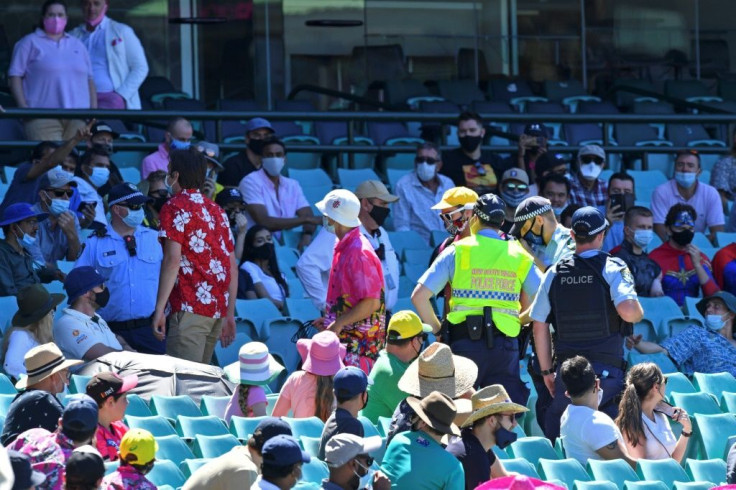 Police remove speactators from a section of the crowd after the third Test was halted just before tea on Sunday