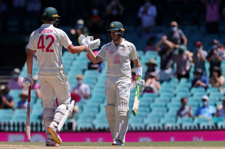 Cameron Green (left) is congratulated by captain Tim Paine after making his maiden Test half-century on the fourth day in Sydney