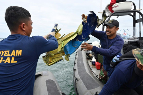 Indonesian Navy divers retrieve wreckage from the Sriwijaya Air Boeing 737-500 aircraft