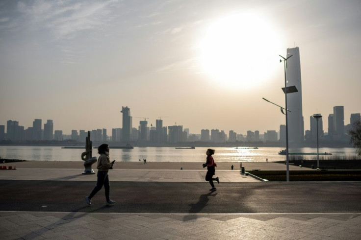 People run along the banks of the Yangtze River in Wuhan on the first anniversary of China confirming its first death from the COVID-19 coronavirus