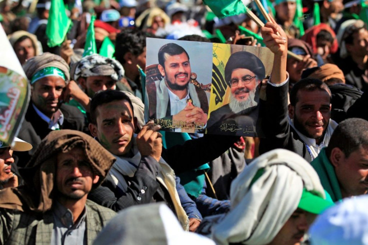 A Yemeni man holds up pictures of Huthi rebel leader Abdul Malik al-Huthi (left) and chief of the Shiite Muslim movement Hezbollah Hassan Nasrallah