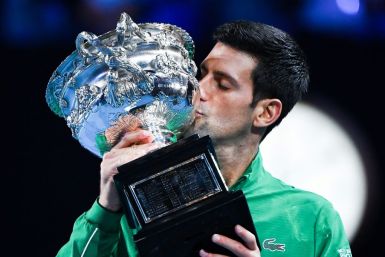 World number one Novak Djokovic kisses the Australian Open trophy following his victory against Austria's Dominic Thiem in the 2020 final. This year the top stars face the threat of sanctions if they breach stringent Covid-19 protocols