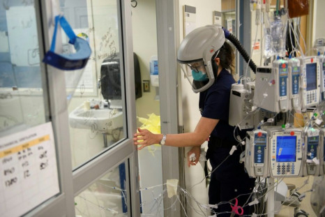 A nurse wearing personal protective equipment (PPE) including a personal air purifying respirator closes a door to a patients room in a Covid-19 intensive care unit at Martin Luther King Jr. Community Hospital on January 6, 2021 in Los Angeles