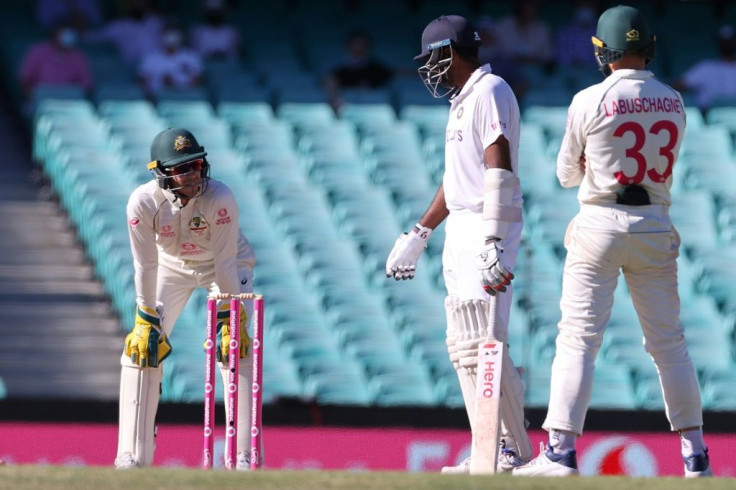 India's Ravichandran Ashwin (centre) has words with Australia captain Tim Paine (left) as Australia's Marnus Labuschagne watches during a tense final day in Sydney