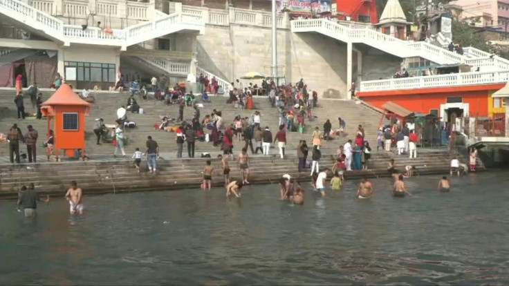 Hindus in Haridwar, India gear up for mass religious festival Kumbh Mela, with some people bathing by the riverside as construction workers make preparations.