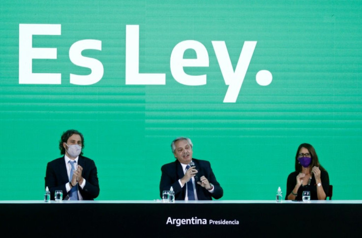 Argentina's President Alberto Fernandez (C), speaks next to Cabinet Chief Santiago Cafiero (L) and the Minister of Women, Genders and Diversity, Elizabeth Gomez Alcorta, during the promulgation ceremony of the abortion law January 14, 2021